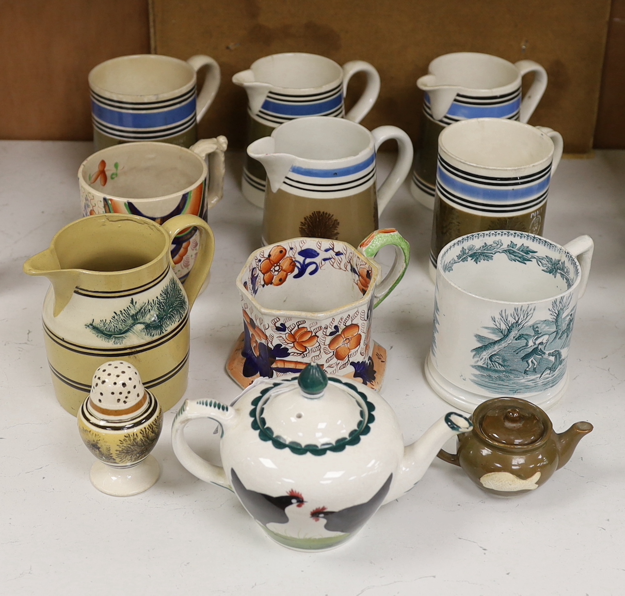 A group of Mocha ware, three various earthenware mugs, a Wemyss-style teapot, etc. (12)